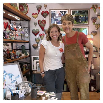 Artist Emily Frushour and the owner of Two Fish Gallery store in Leland, Michigan, standing together during a store event.