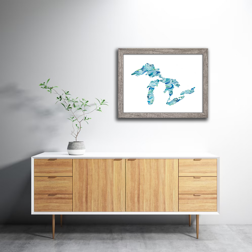 Framed watercolor painting of the Great Lakes, with waves in brilliant shades of blue and green, hanging in a living room.