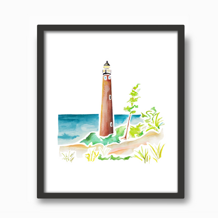 Black frame with watercolor painting of Little Sable Point Lighthouse on Lake Michigan, surrounded by sand dunes and grass.