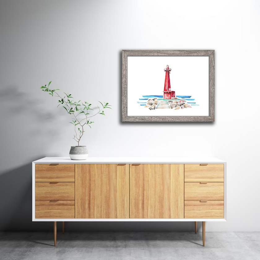 Gray frame with bright watercolor painting of the Muskegon lighthouse in vibrant red, with stone pier and Lake Michigan.