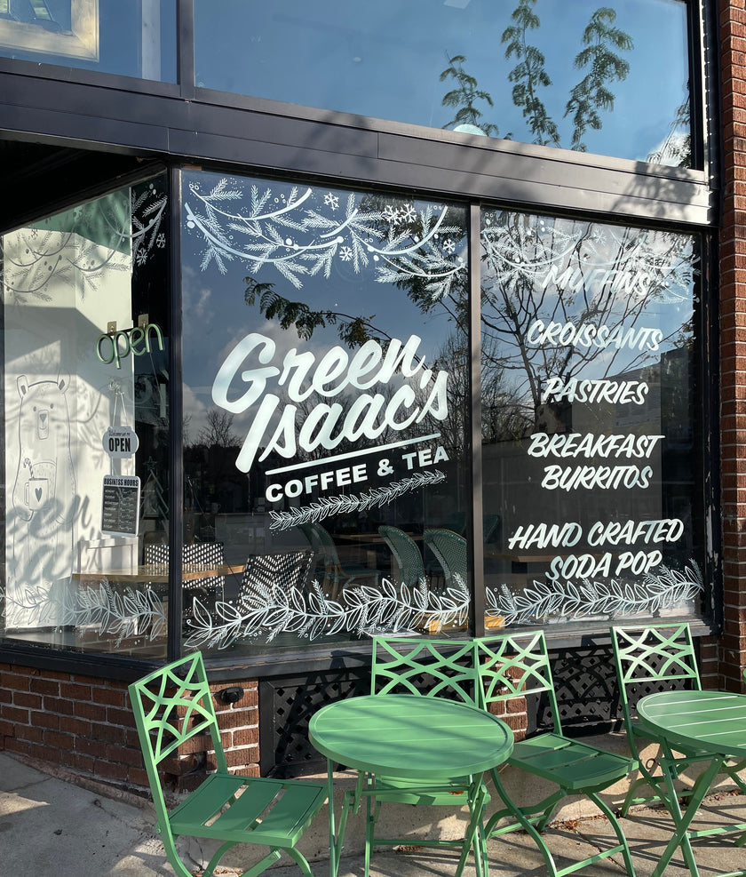 Delicate window art illustration showing pine branches, leafy garland and snowflakes, created by artist Emily Frushour.
