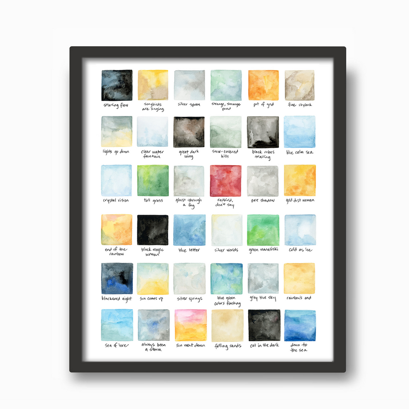 Colorful geometric watercolor swatches correlating to song lyrics in a black frame on a wall.