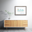 Colorful watercolor print of a green and blue tandem bike with the words Mackinac Island, in a gray frame in a home.