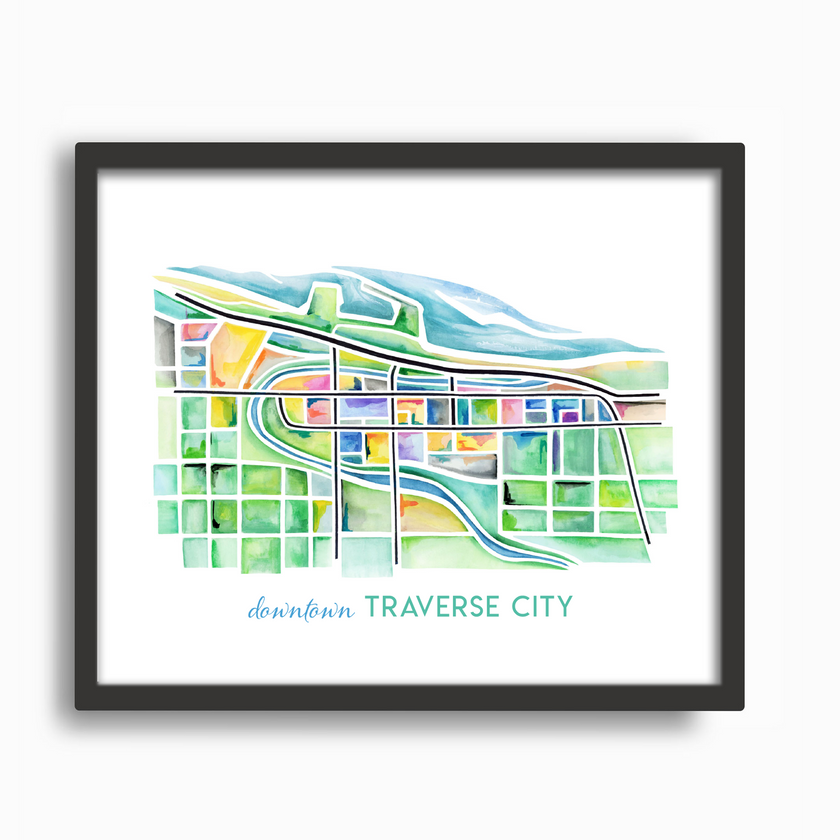Bright and colorful watercolor painting showing a map of Traverse City, Michigan, in vibrant greens and blues, placed in a simple black frame.