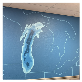 Wall mural showing a map of Lake Michigan and the Great Lakes painted in shades of blue.