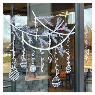Delicate window art illustration showing pine branches with hanging Christmas ornaments, created by artist Emily Frushour.